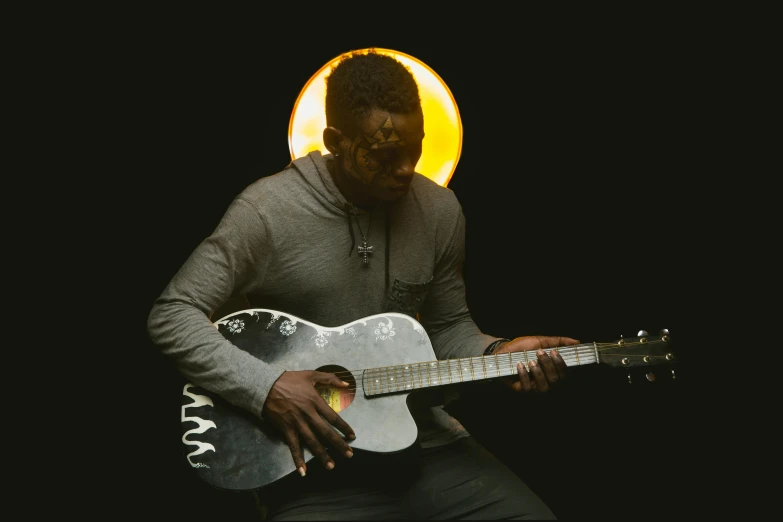 a man playing an acoustic guitar in the dark