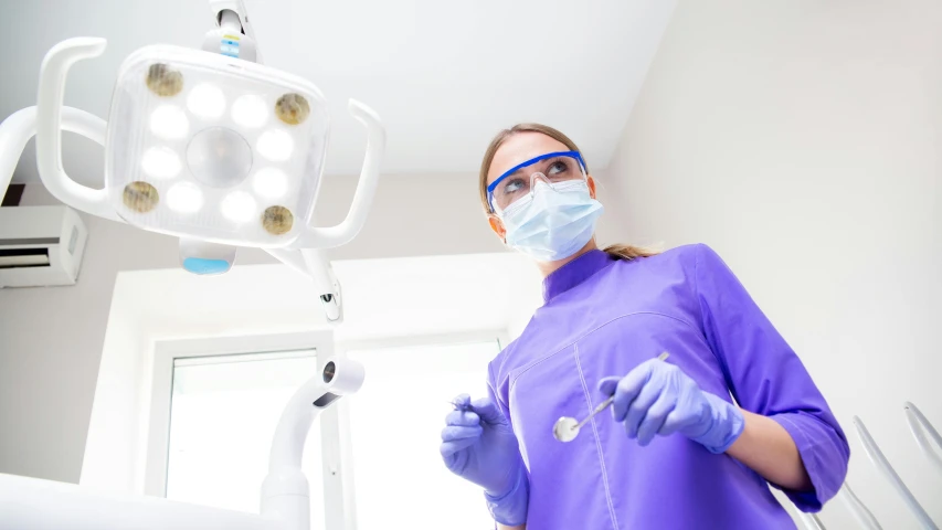 a woman wearing scrubs in front of a medical light