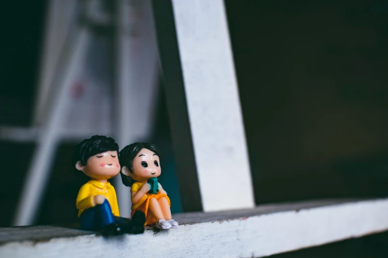 a couple of toy figures sitting on top of a rail