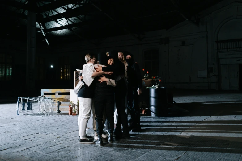 two men are hugging while two women watch