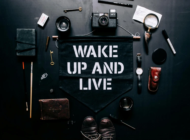 various items arranged on black surface such as hat, camera and other items