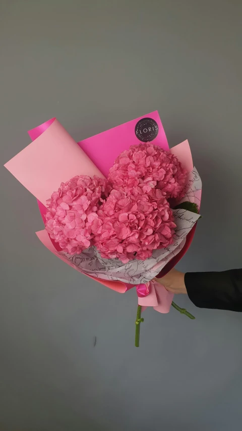 a person holds flowers with a large wrapper on them