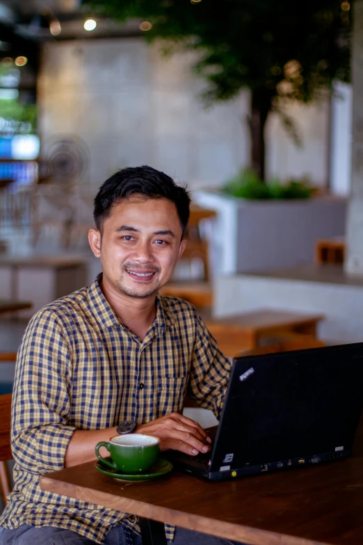 a man sitting at a table using a laptop