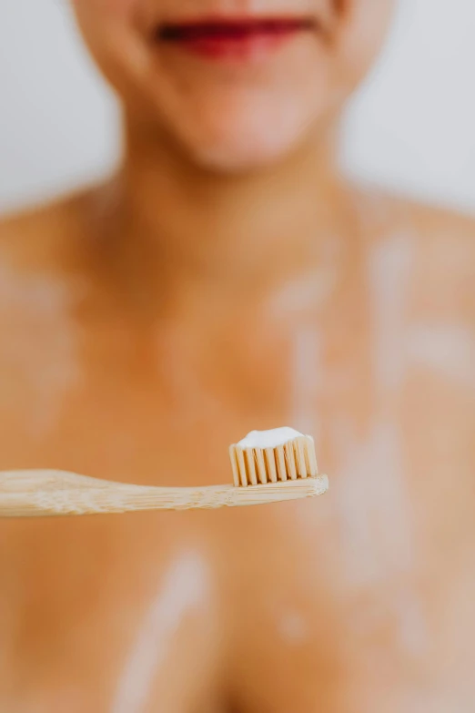 a toothbrush is being held by someone with skin all over their body