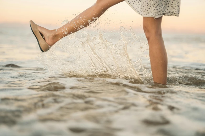 a woman's legs running into the ocean water