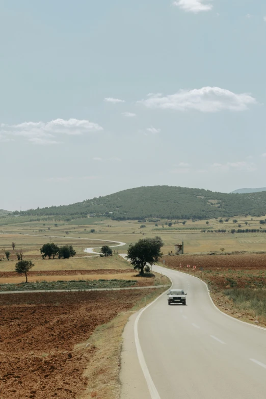 an empty street leading into an open landscape