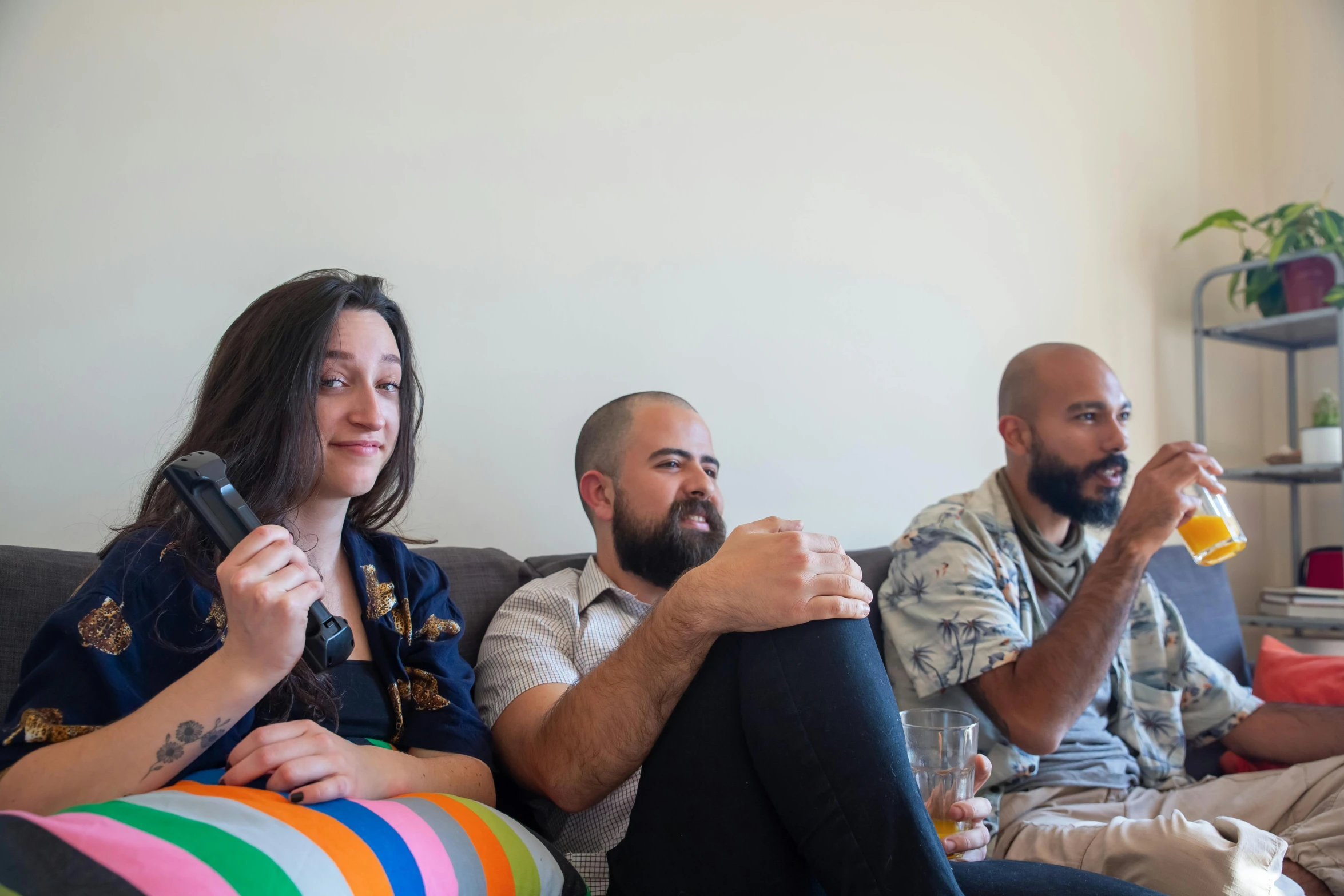 three people on the couch drinking orange juice