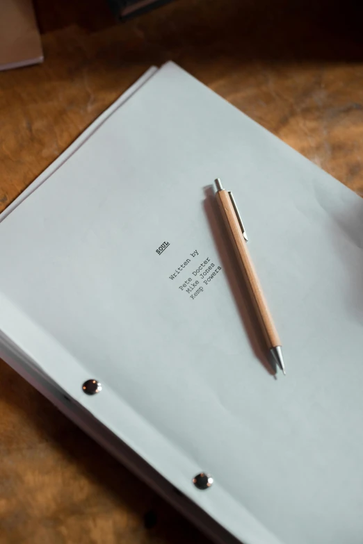 a white folder with a pen on it