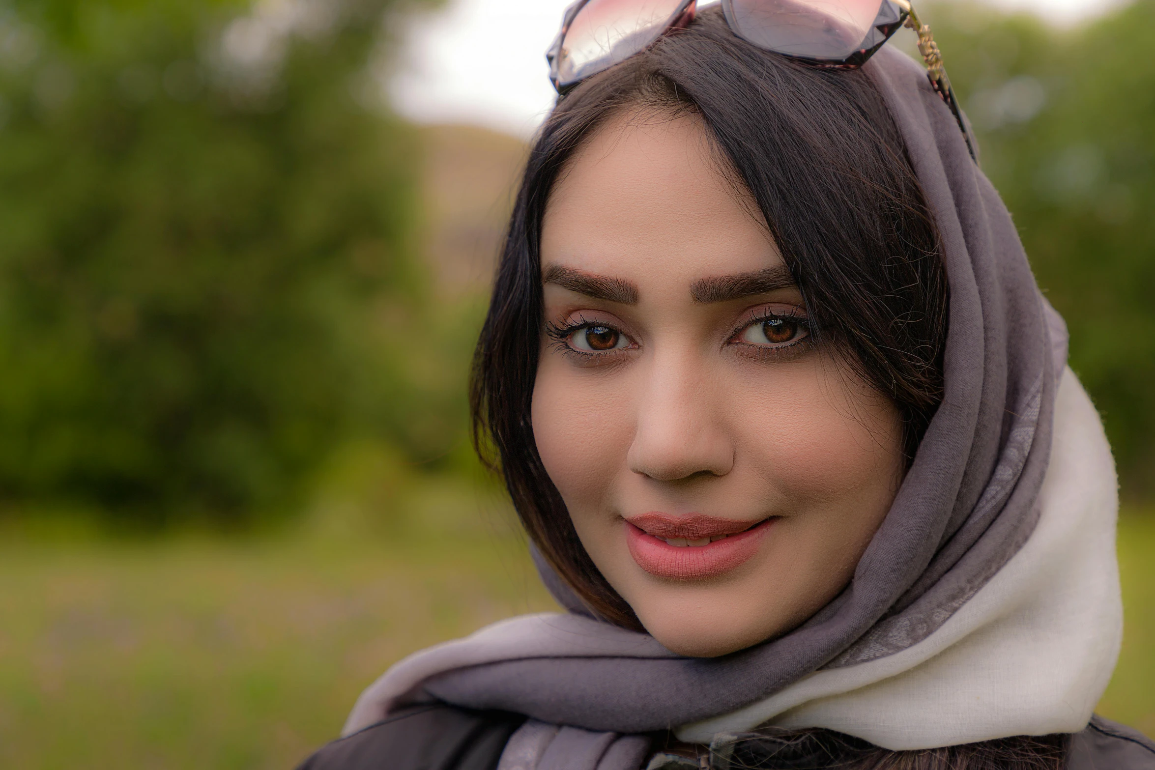 a woman with glasses looking off into the distance