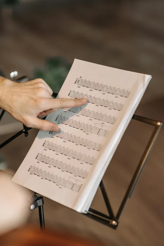 a person is holding a sheet of paper while sitting in a chair