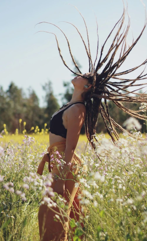 woman with dreadlocks in a field of flowers