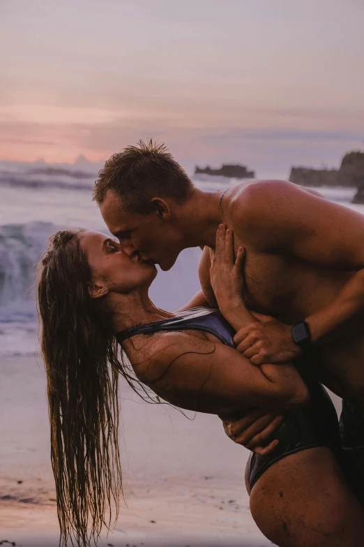 a young couple is posing for a picture by the beach