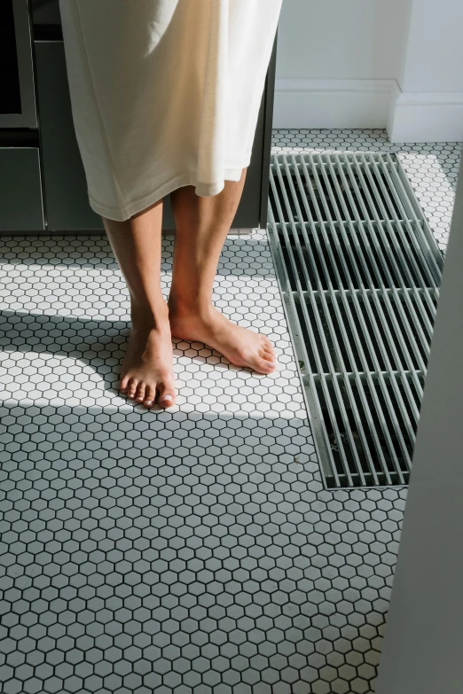 a person's bare foot on the floor of a bathroom