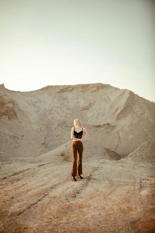 the woman in a short black shirt is standing on the sand