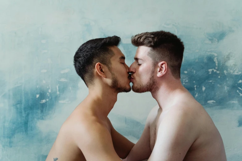 two men are kissing each other on a blue background