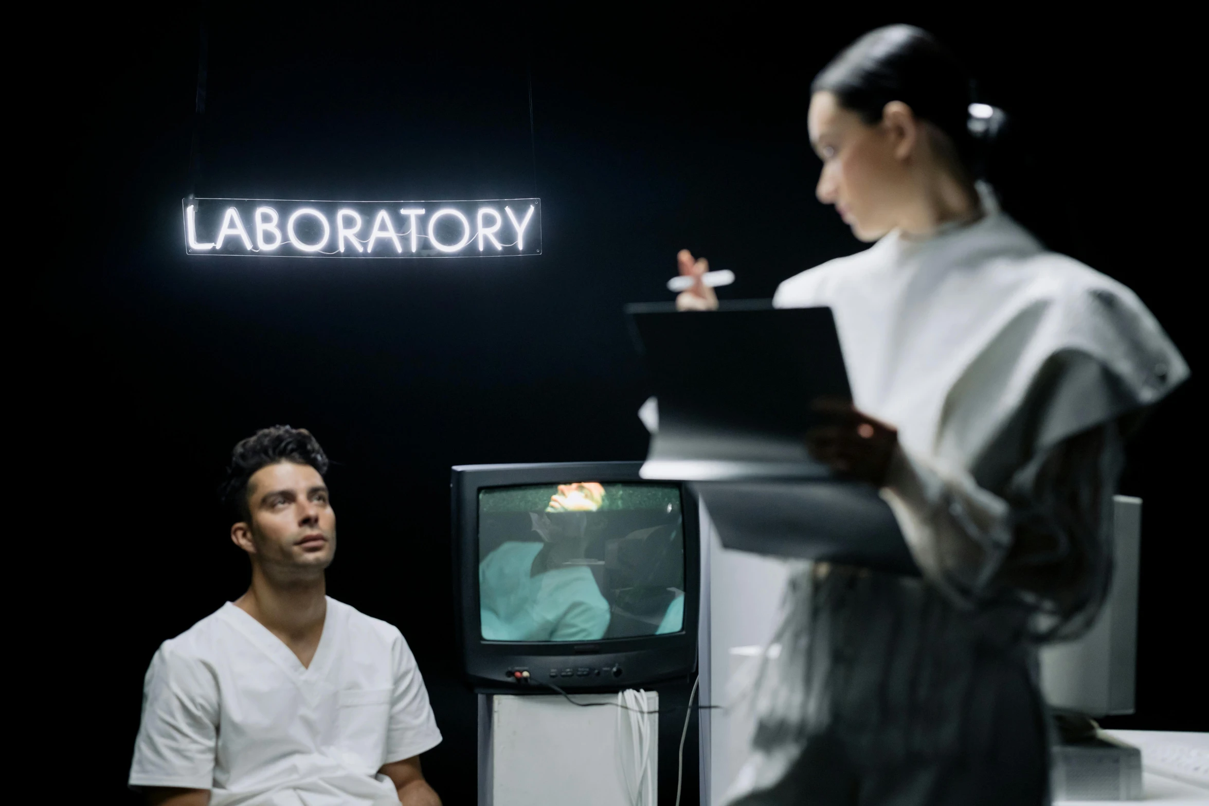 a man and a woman are looking at a television