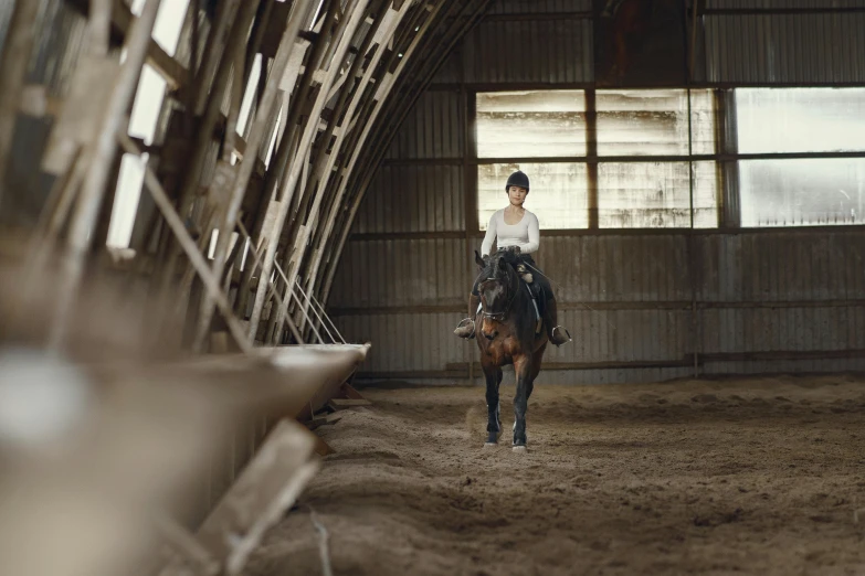 a woman riding a horse in an enclosed area