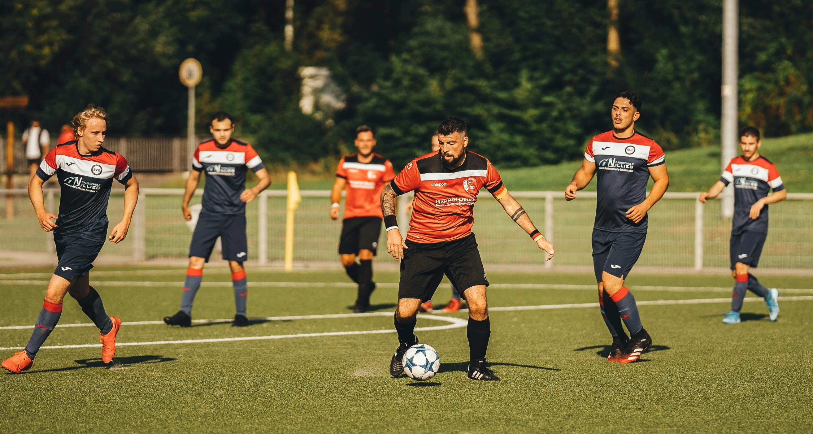 a group of people standing around a soccer ball on a field