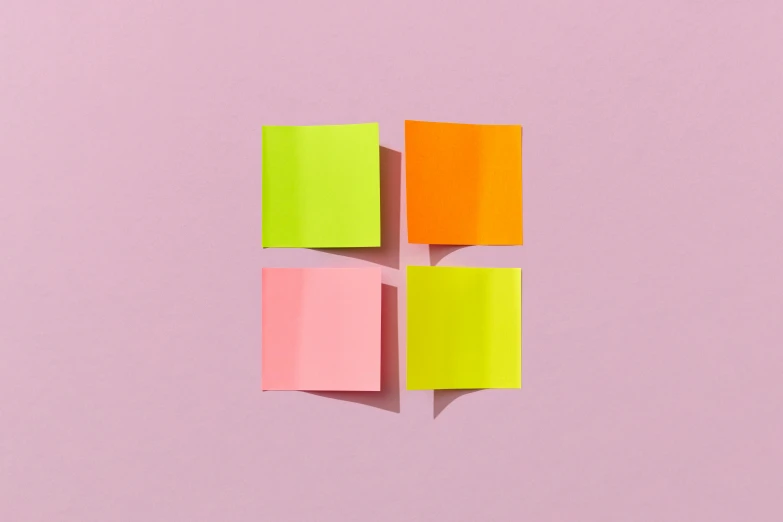 a pink and yellow post - it notes on top of each other