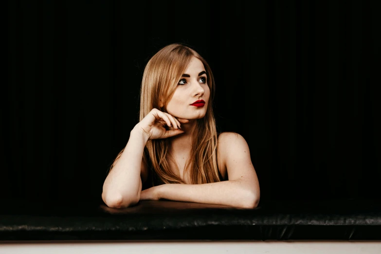 a beautiful young lady is sitting on a bench