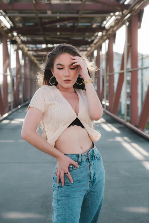 a woman posing in jeans with an open shirt and high heels