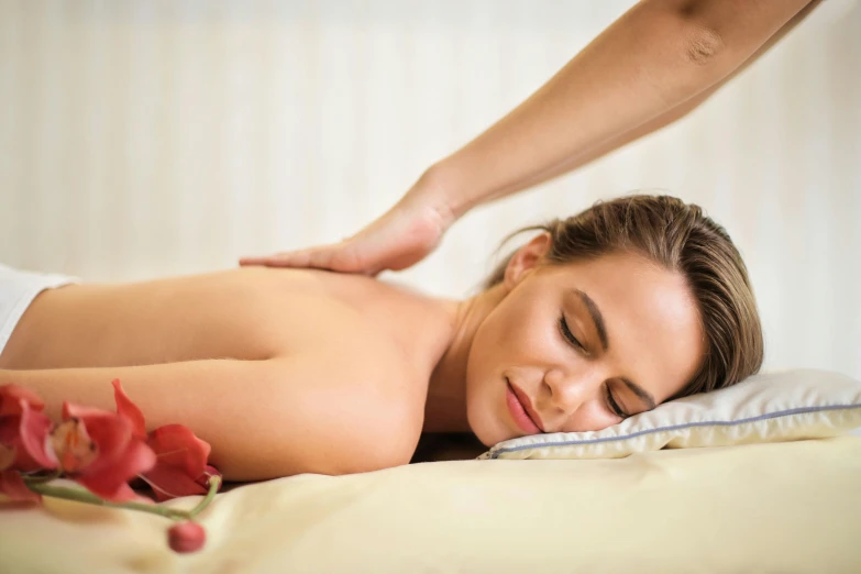 a woman laying down and being massaged by a male