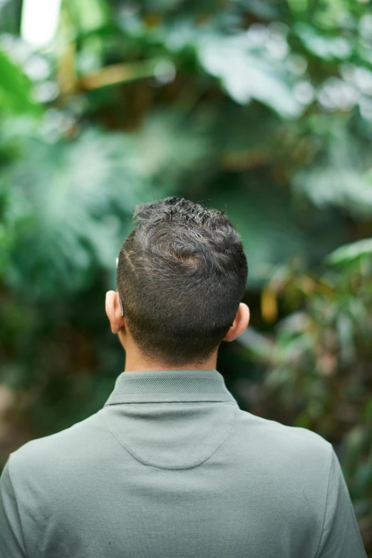 a man with a shaved back in a green jacket