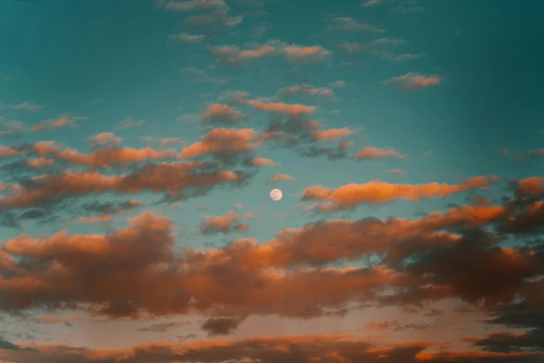 clouds and a setting moon in a deep sky