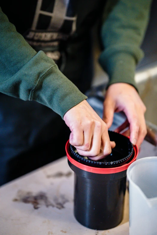 the person puts the lid on a cup