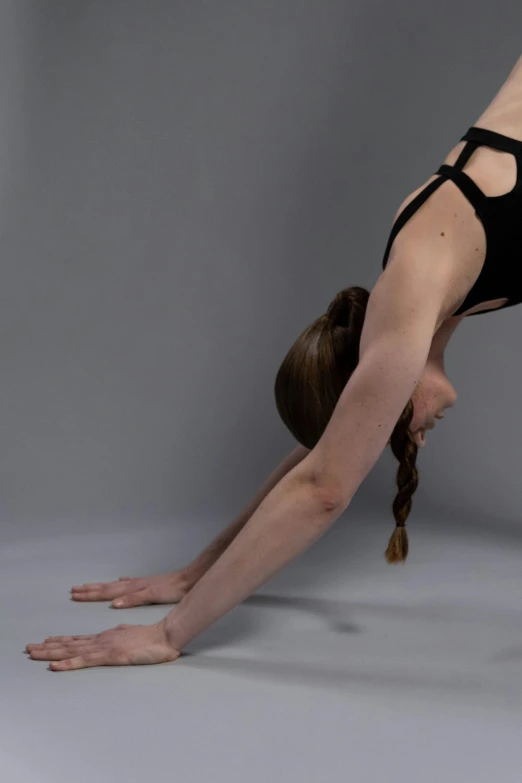 a girl is doing a pose on her yoga mat