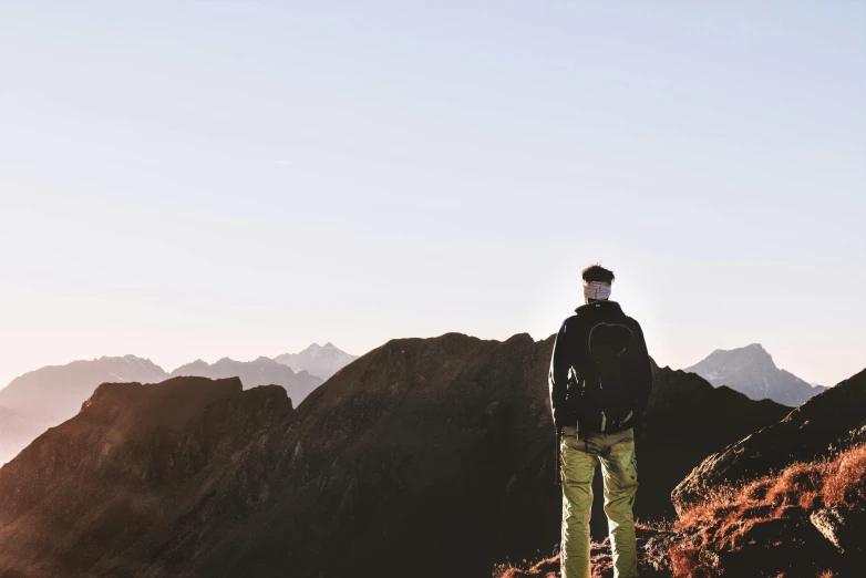 the person in black jacket stands on the mountain