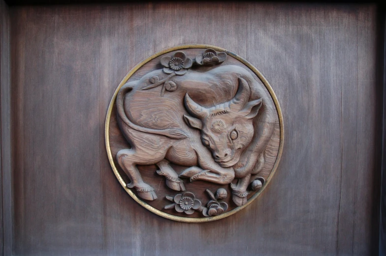 a wooden panel with a carving of an animal on it