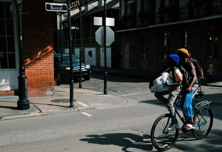 a boy riding a bike with another boy on the back