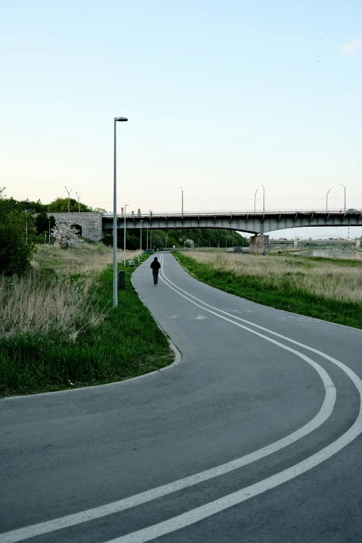 man riding a motorcycle down an empty road