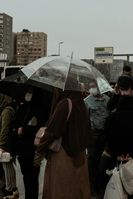 a group of people holding umbrellas walking in the rain