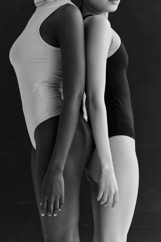 two girls standing with their backs turned to one another