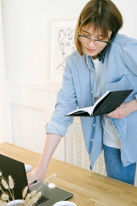 the woman in glasses is typing on her laptop