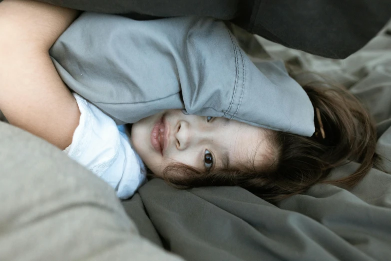 a boy is laying down in bed with a pillow