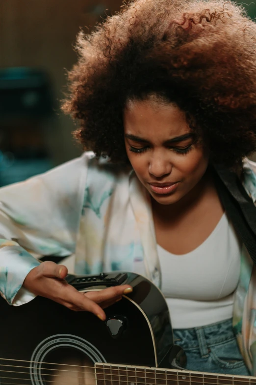 there is a woman that is playing a guitar