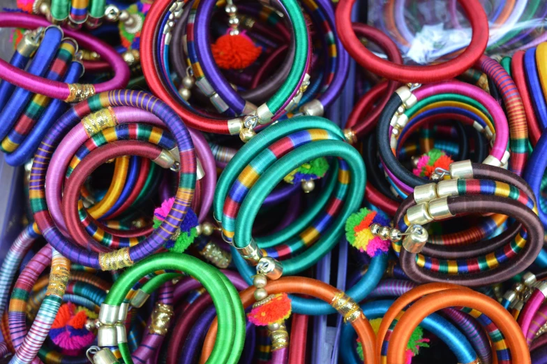 a collection of bright colored celets and rings