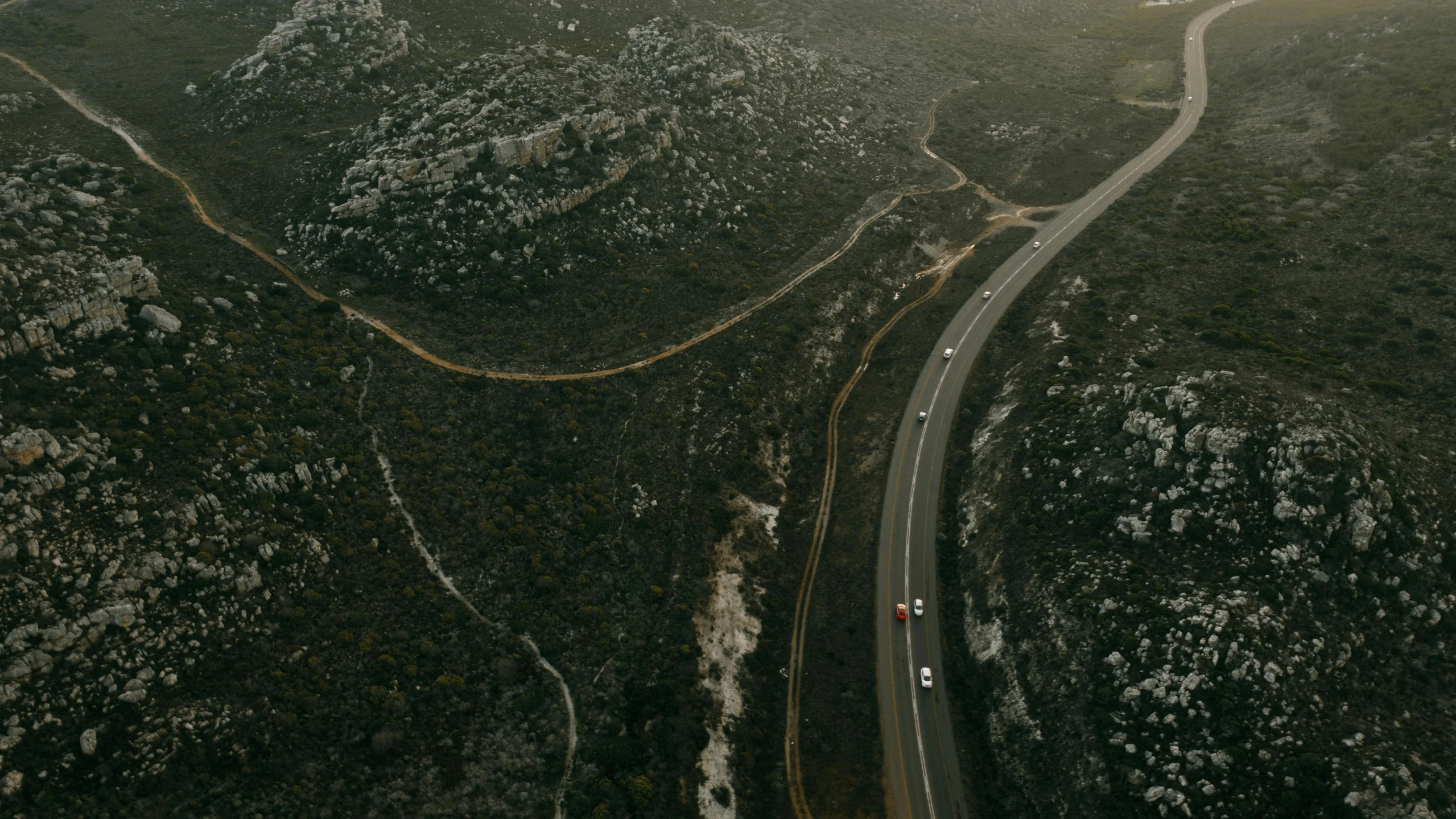 a long and narrow road on the side of a mountain range