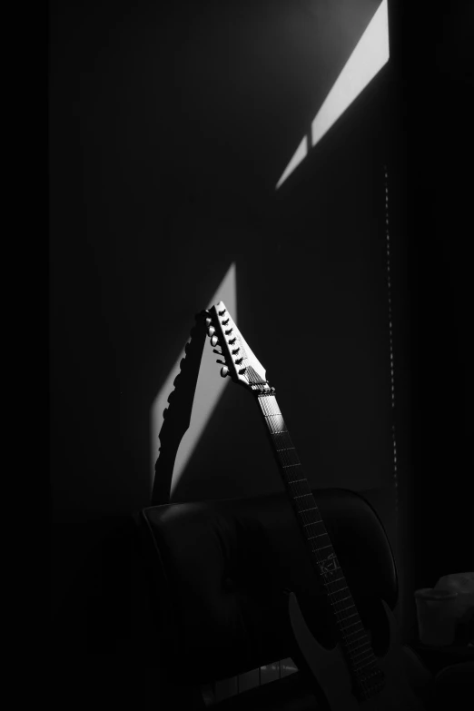 black and white image of an acoustic guitar in the shadow