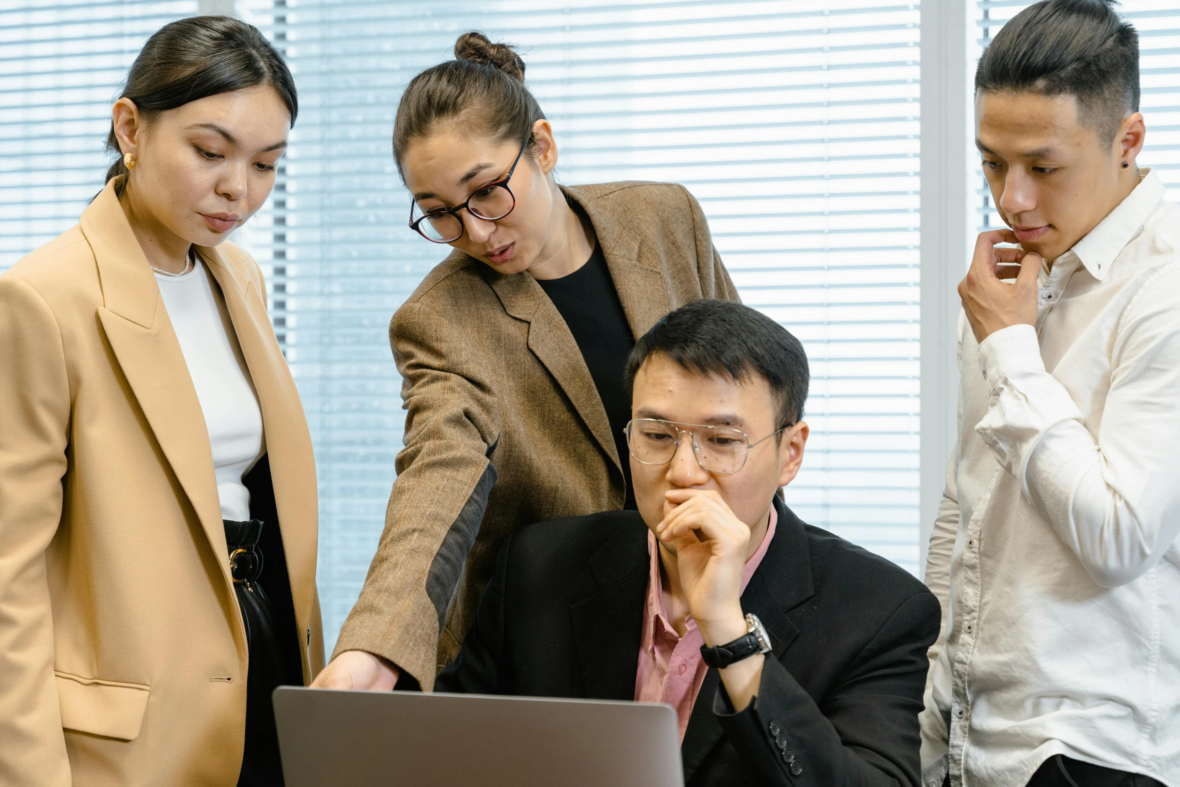 three business people looking at a laptop screen