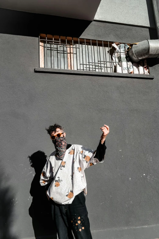 man with shades on standing on the sidewalk