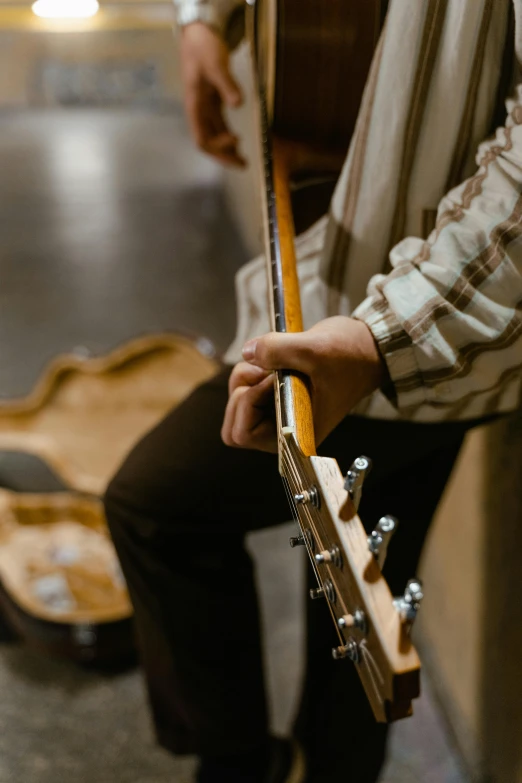 the man is playing guitar inside his house