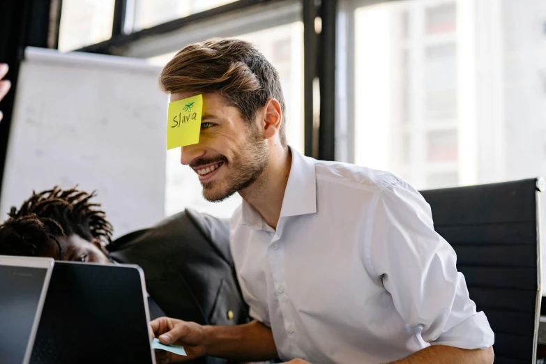 a man has yellow sticky note on his face