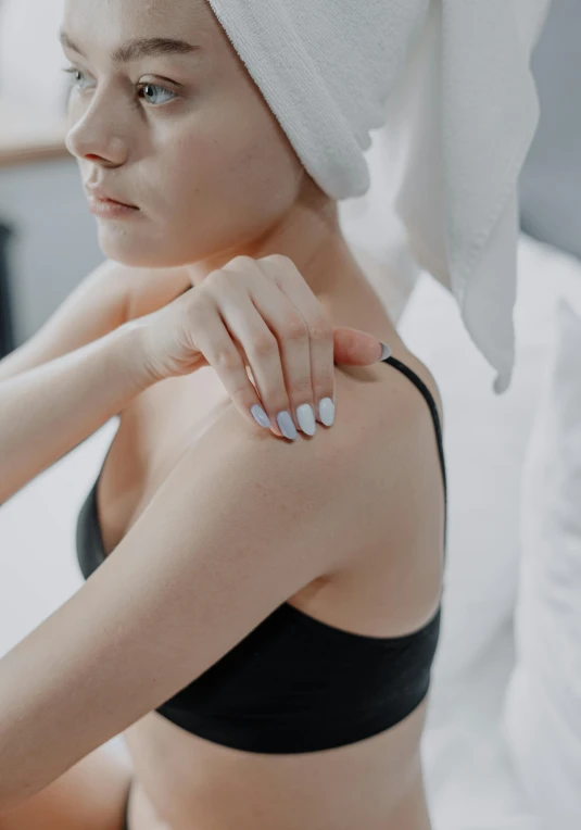 a woman is putting on a towel over her head