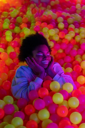a person standing in an enormous bunch of colorful balls