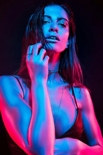 a woman in a bikini posing with a red and blue light