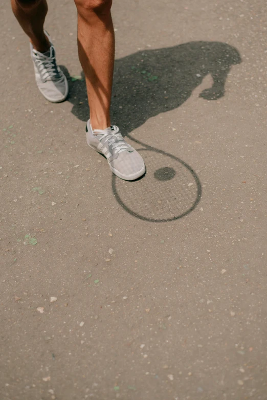 a man's foot and shoe is reflected in the reflection of his shadow